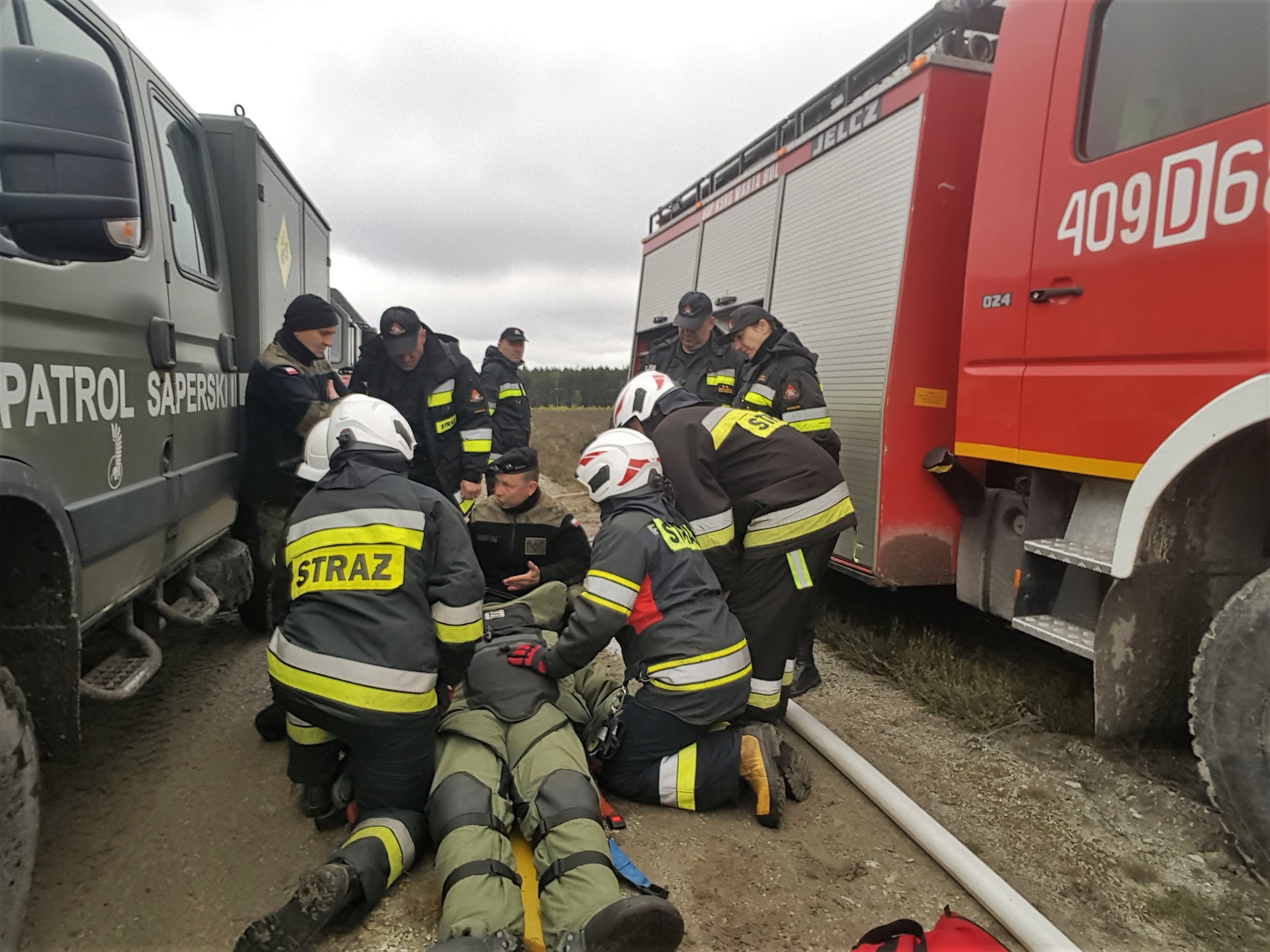 Strażacy udzielający pomocy rannemu saperowi / fot. Janusz Wilk
